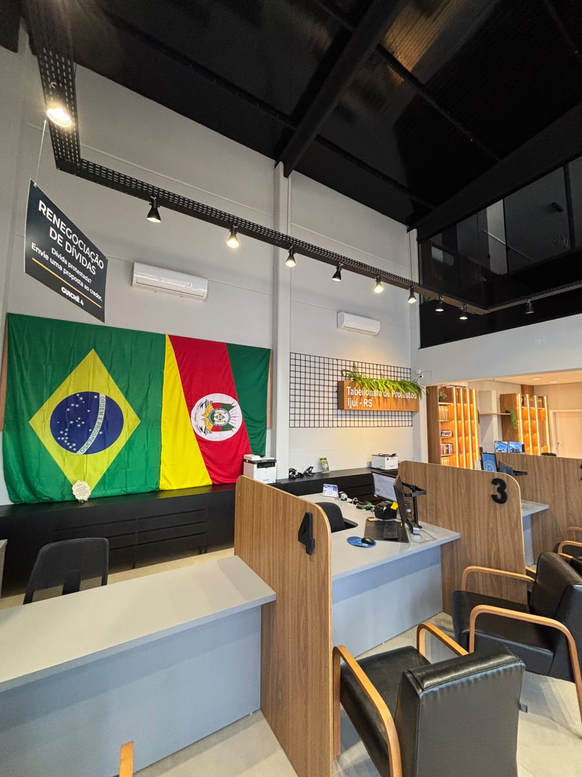 Salão de atendimento do Tabelionato de Protestos de Ijuí, com bandeiras do Brasil e do Rio Grande do Sul